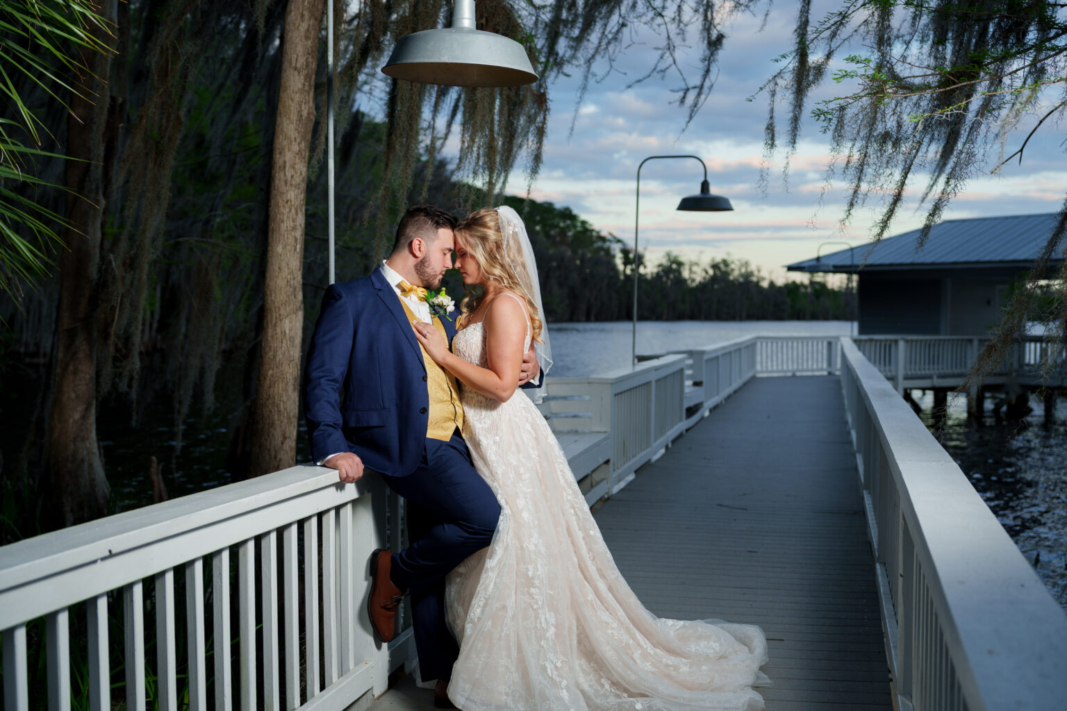 Orlando bride and groom embracing on a lakeside dock at dusk