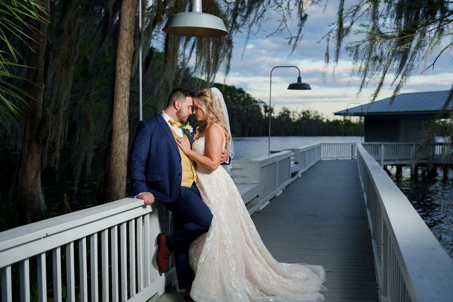 A couple embracing on a lakeside dock at dusk